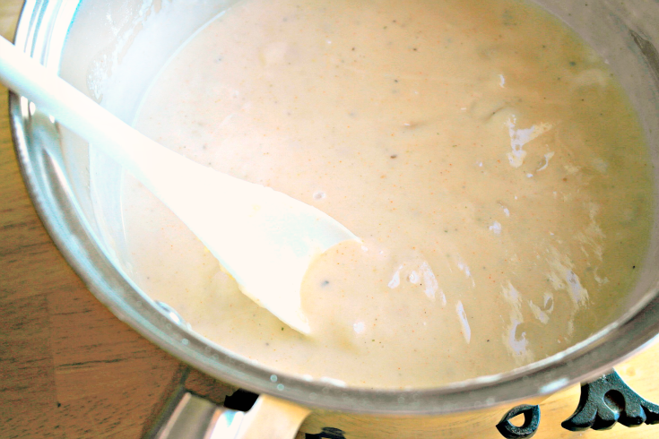 stirring cheese sauce in a pan