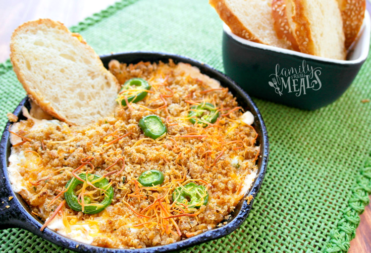 Easy Jalapeno Popper Dip in a cast iron pan with a slice of bread