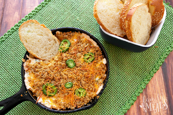 Easy Jalapeno Popper Dip in a cast iron pan with a bowl of sliced bread