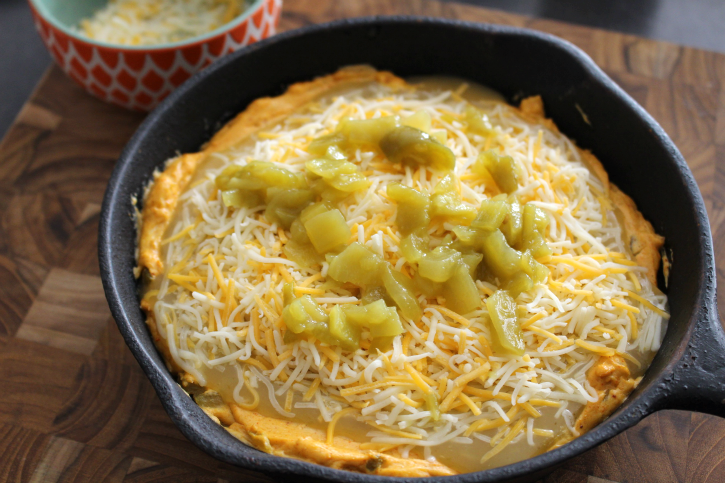 Chili Relleno Dip in cast iron pan, topped with green chilis