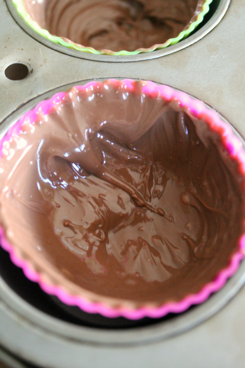 layer of melted chocolate in muffin cups