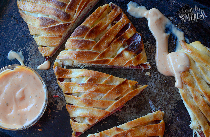 Corned Beef Sauerkraut Reuben Braid on a sheet pan with sauce