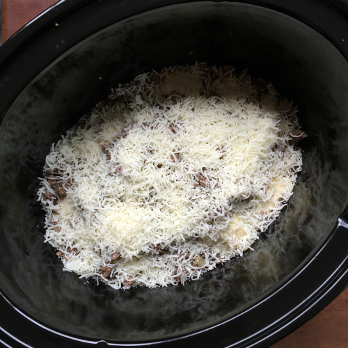 Easy Crockpot Lasagna Ravioli - Shredded cheese add to top of pasta