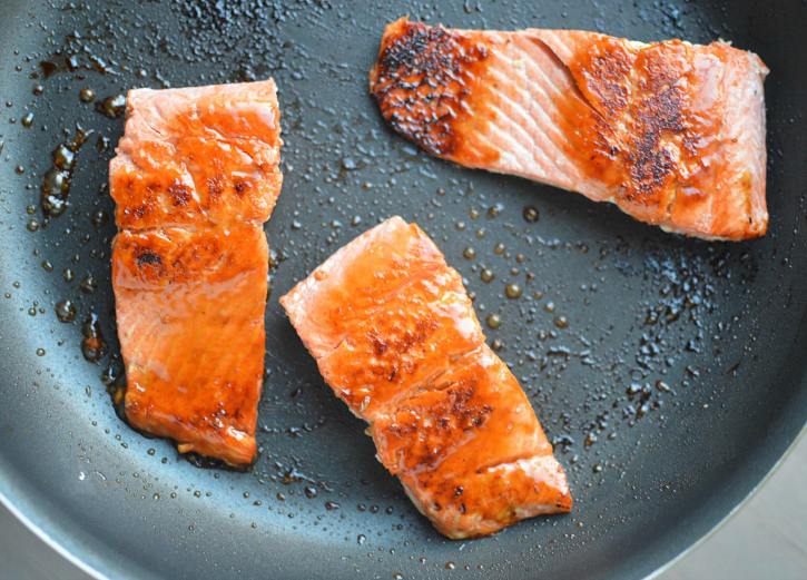 Easy Honey Glazed Salmon - salmon filets cooking in a pan