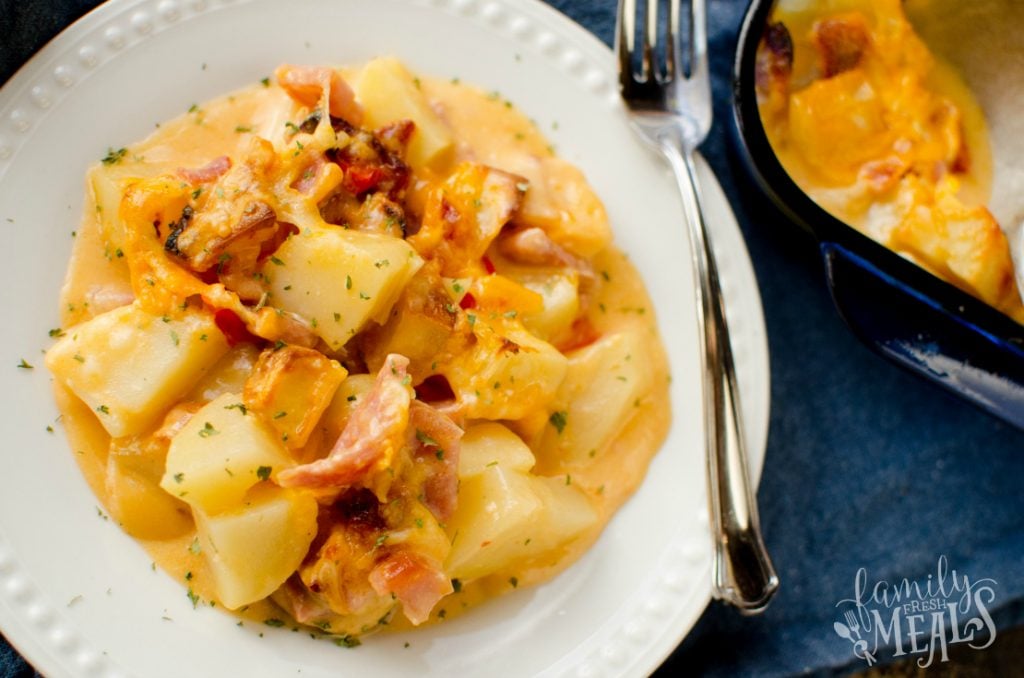 Cheesy Ham and Potato Casserole - Cheesy Potatoes recipe served on a white plate