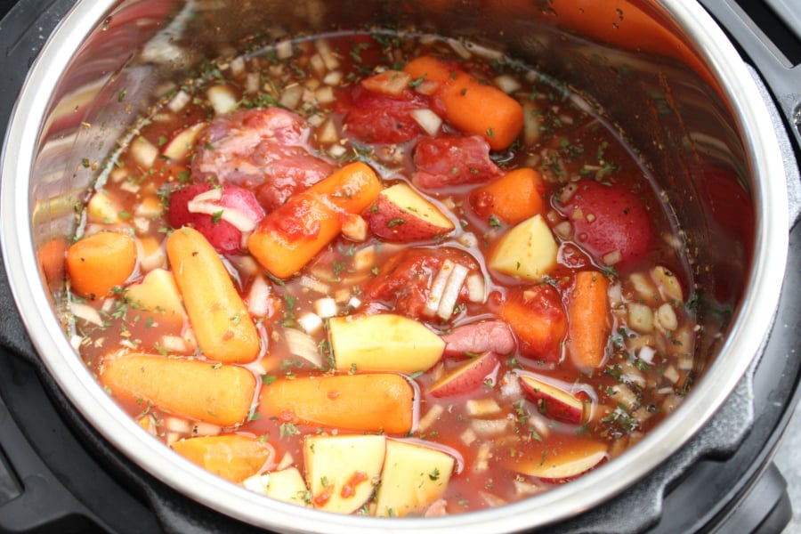 The Best Instant Pot Beef Stew - potatoes, carrots, broth, and tomato pasted added into Instant Pot pressure cooker