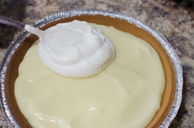 Grandma's Banana Cream Pie - Placing whipped cream on top of pie