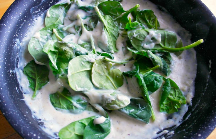 adding spinach into pan