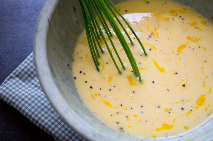 Meat Lovers Breakfast Bake Slab - eggs being whisked in a grey bowl