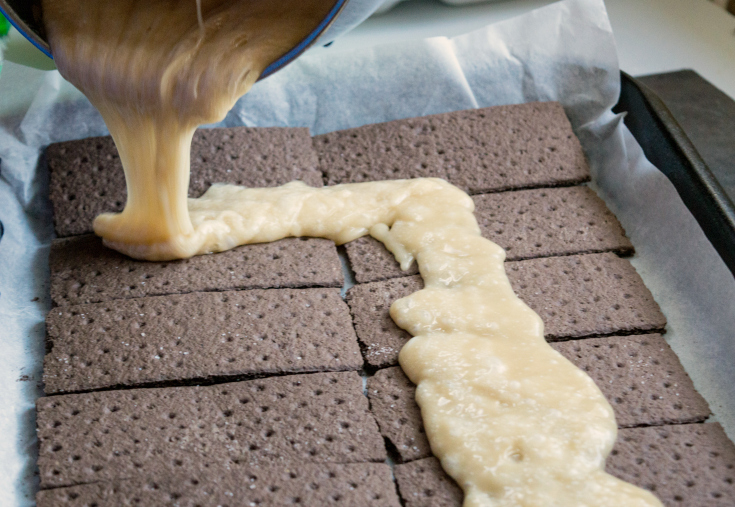 Andes Chocolate Toffee Bark - Pouring melted mixture over crackers