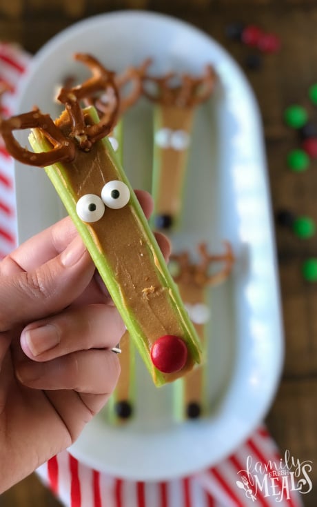 Reindeer Snacks - Holding celery stick with peanut butter and pretzels