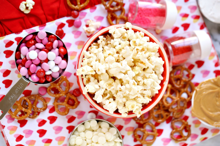 Valentines' Snack Mix with Free Printables - Ingredients of popcorn, pretzels m&m's white chocolate and peanut butter