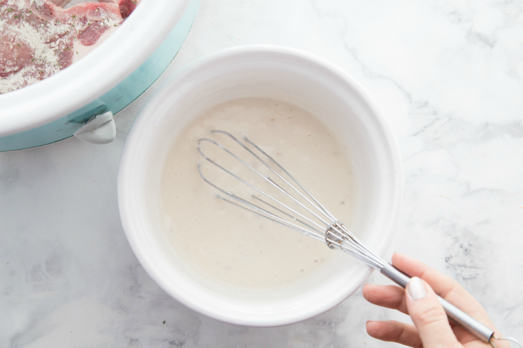 Whisking sauce in a white bowl