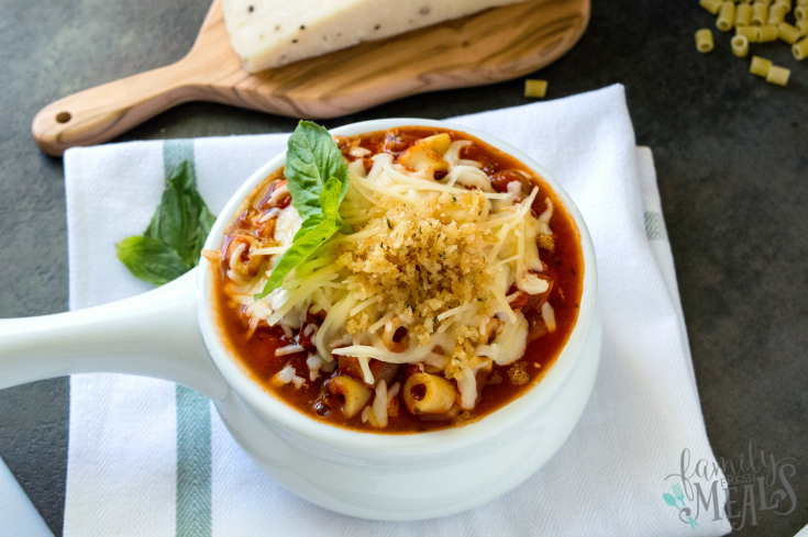 Soup in a white bowl topped with cheese and bread crumbs