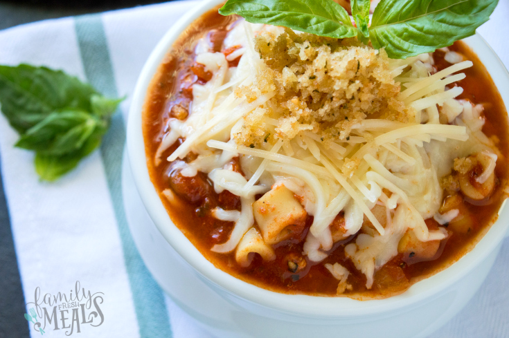 Soup in a white bowl topped with cheese and bread crumbs