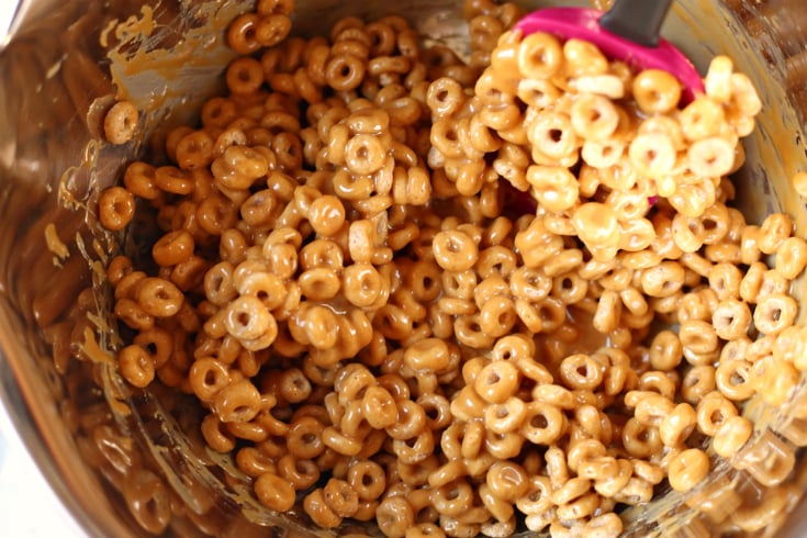 No Bake Chocolate Caramel Cereal Bars - Mixing together cheerios and caramel