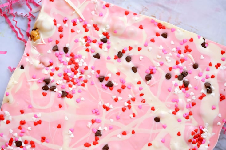 No Bake Chocolate Caramel Cereal Bars - Pink and white chocolate and sprinkles drizzled on top of cheerios