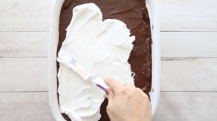 OMG Chocolate Lasagna Dessert - Spreading whipped cream on top of chocolate pudding