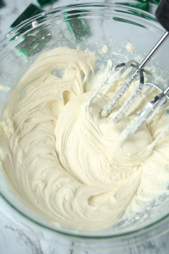 Mint Chocolate Chip Dip - white dip mixed with hand mixer in a glass bowl