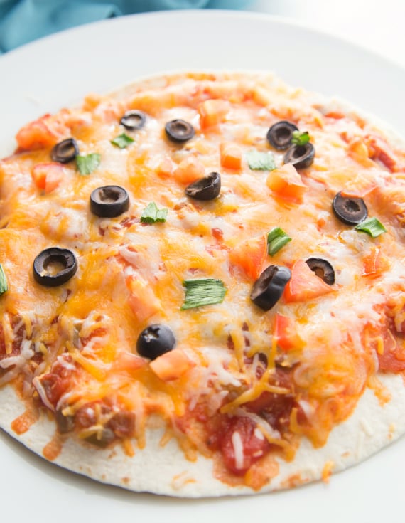 Copycat Taco Bell Mexican Pizza Stacks - Tortillas topped with melted cheese, olives, tomatoes and green onions