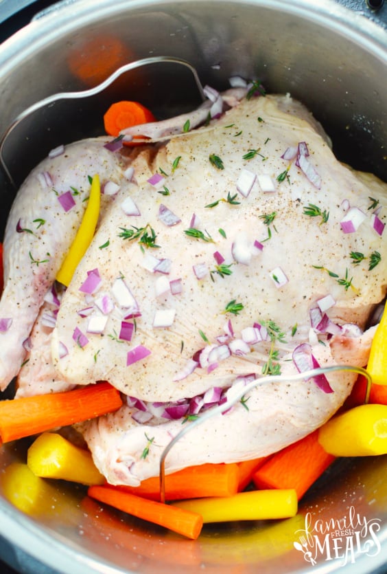 How to Make an Instant Pot Whole Chicken - Whole chicken, carrots and seasoning in the Instant Pot - Family Fresh Meals 