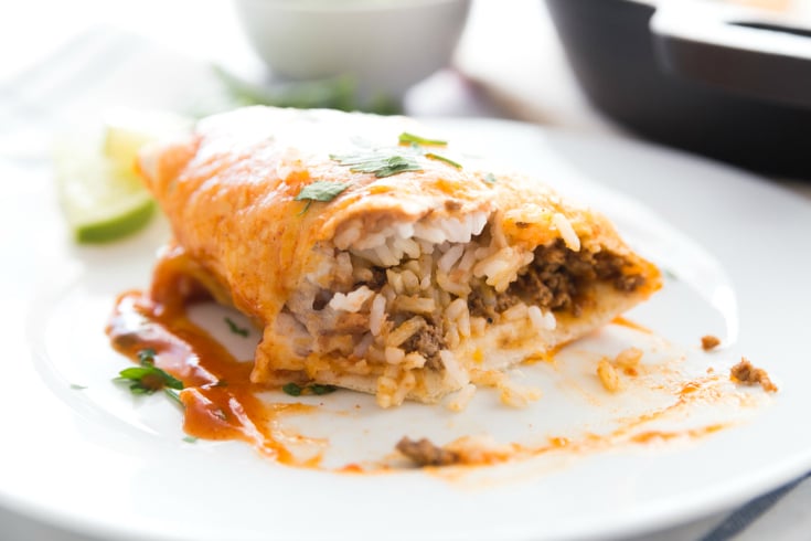 One Pan Smothered Beef Skillet Recipe - Burrito cut in half on a white plate