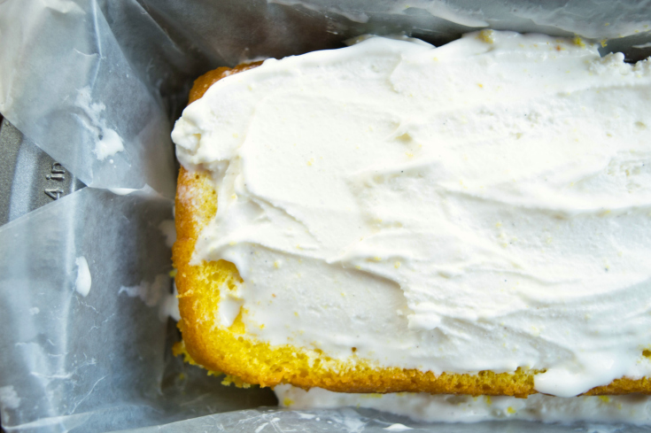 Easy Lemon Ice Cream Cake - Sliced cake in bread pan with ice cream spread on top