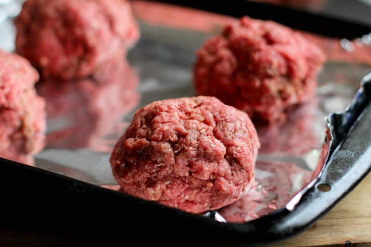 Fully Loaded Burger Bowls - balls of raw hamburger meat on a foil lined baking sheet