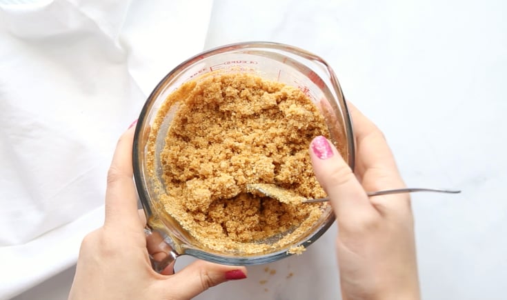 No Bake Cherry Cheesecake Dessert - graham cracker crumbs, butter and sugar mixed in a pyrex mixing cup