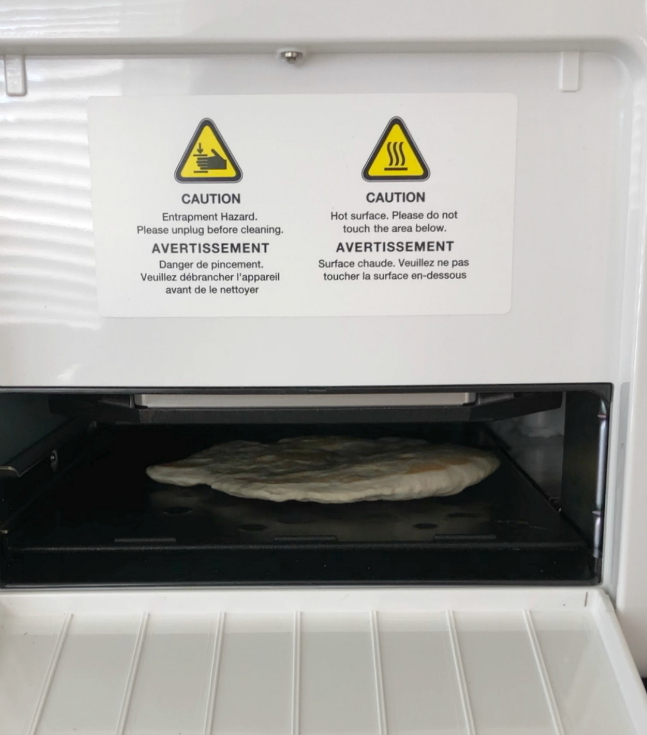 Dough being flattened out into a roti flatbread in the Rotimatic