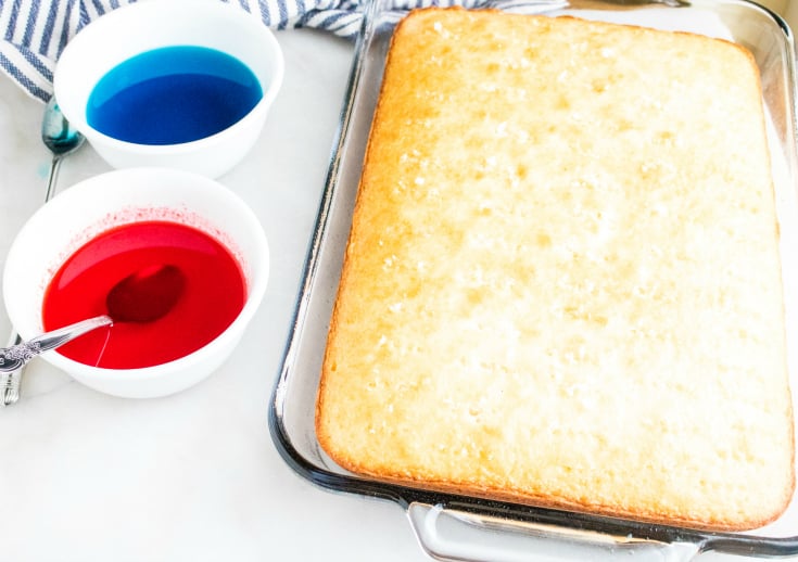 Red White and Blue Poke Cake - White cake baked in a glass baking dish. Two white bowls with red and blue liquid