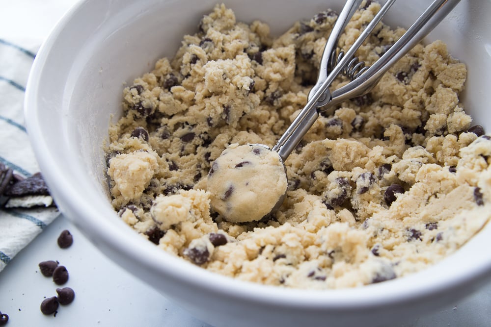 Jumbo Oreo Stuffed Chocolate Chip Cookies Cookie dough being scooped from a white bowl