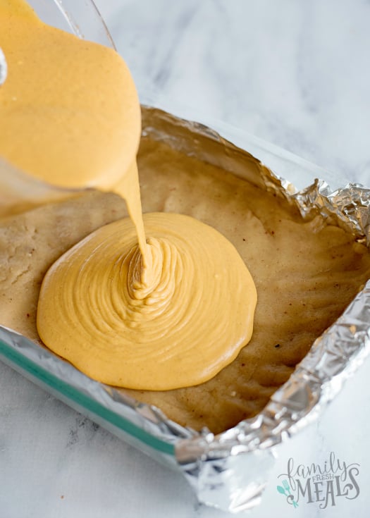 Creamy Pumpkin Pie Bars - pouring pumpkin cream into pan