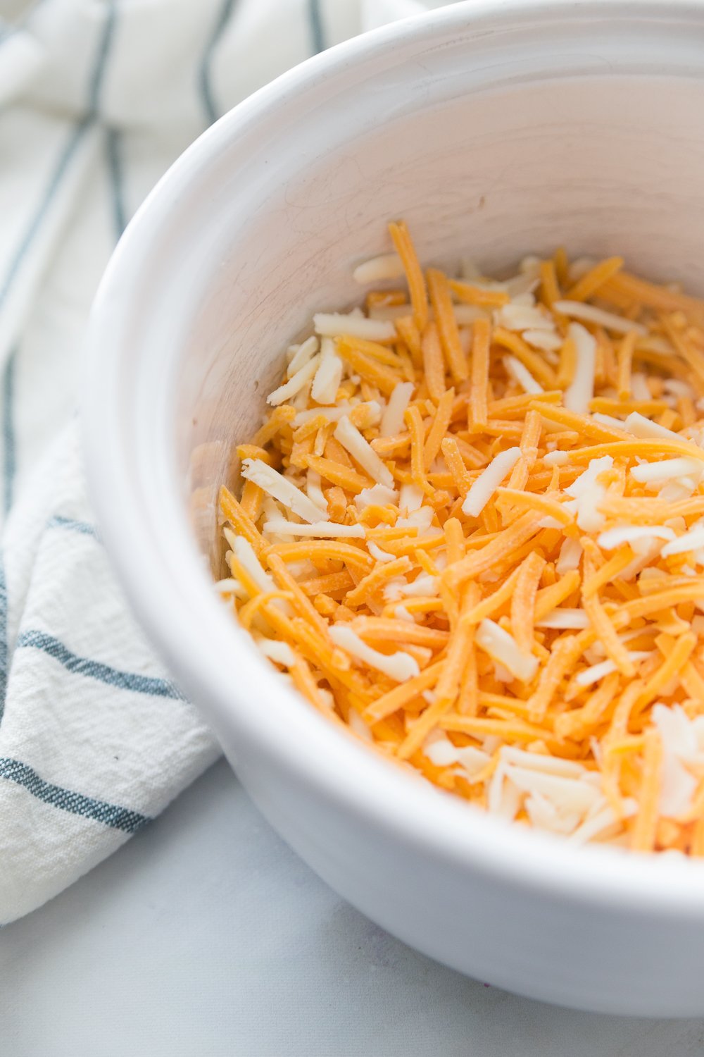 Crockpot Cheesy Cowboy Potatoes - Shredded cheese in a white bowl