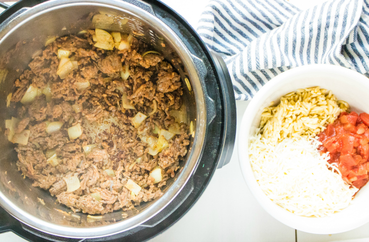 Instant Pot Orzo Sausage Stuffed Peppers - Sausage and onions browning in an instant pot