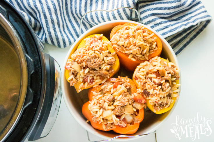 Instant Pot Orzo Sausage Stuffed Peppers - yellow and orange peppers stuffed with orzo, sausage and cheese, in a white bowl
