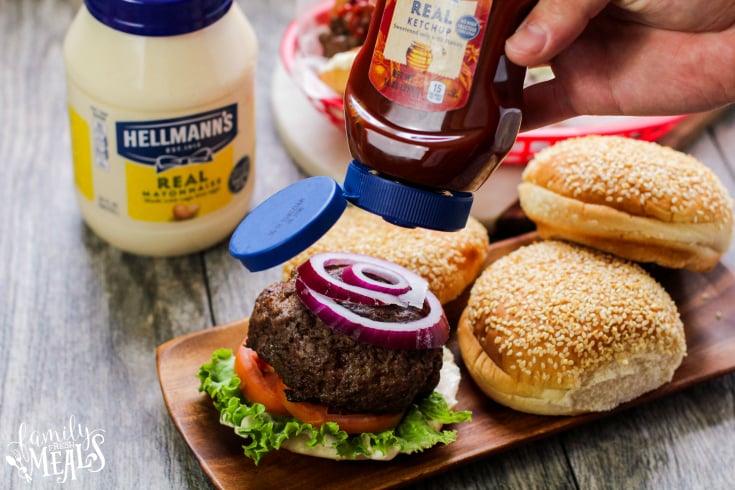 The Best Burgers Recipe - Served on a bun with tomato, lettuce, onion and ketchup