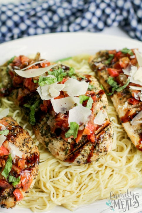 Bruschetta Chicken Recipe Served on a bed of pasta - Family Fresh Meals