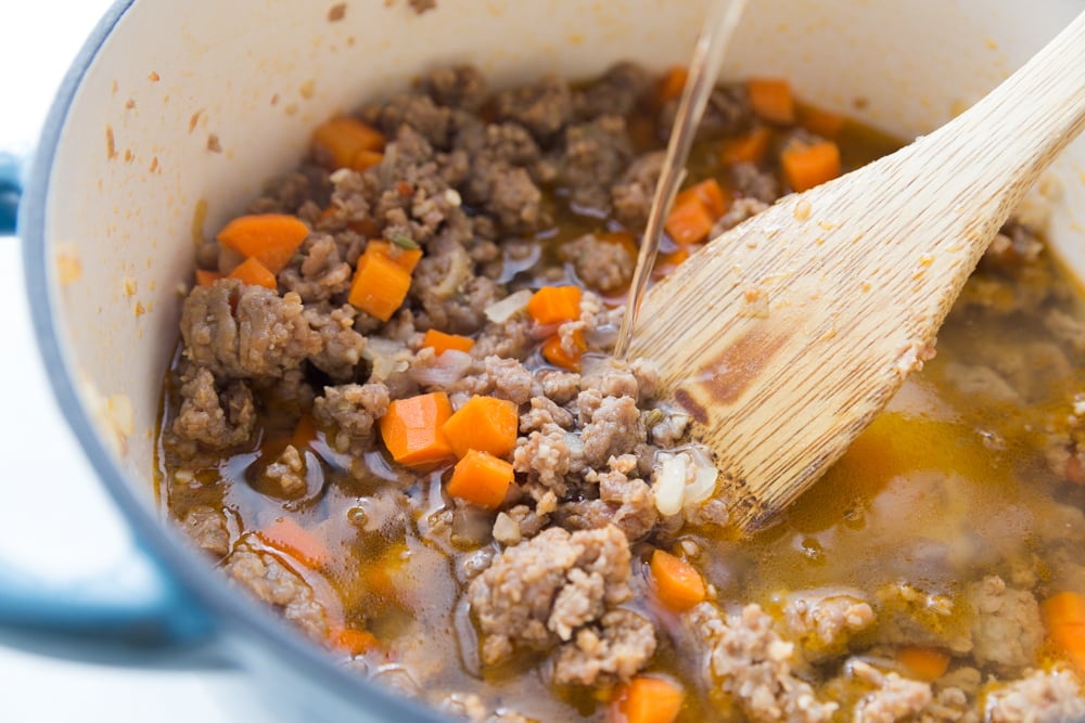 Italian Tortellini Soup Recipe - Broth being poured into dutch oven