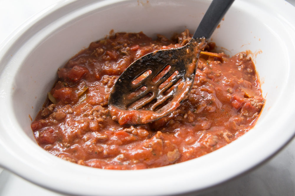 Grandma's Crockpot Lasagna - Sauce added to the top of lasagna in a crockpot