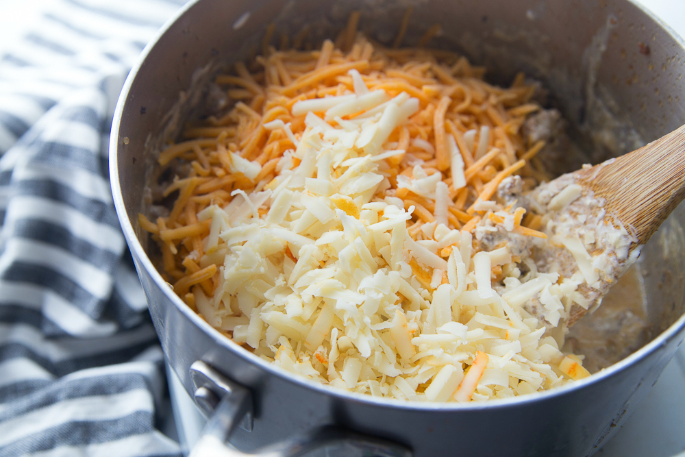 Cheesy Sausage Dip - Stir in shredded cheese with wooden spoon