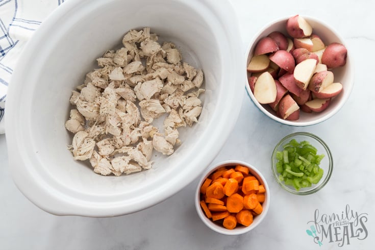 Creamy Crockpot Chicken Vegetable Soup - Chicken in a slow cooker, chopped carrots, celery and potatoes in bowls