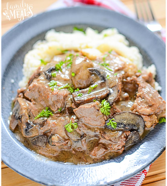 Crockpot Beef with Mushroom Gravy Recipe - Served in a blue bowl and mashed potatoes