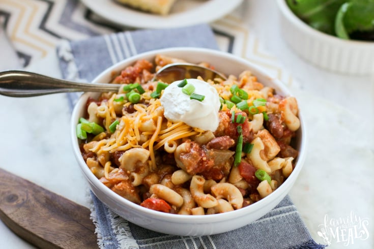 Crockpot Cowboy Chicken Chili Mac - Served in a white bowl and topped with sour cream