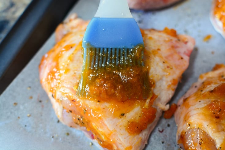 Baked Apricot Chicken - brushing chicken with apricot sauce