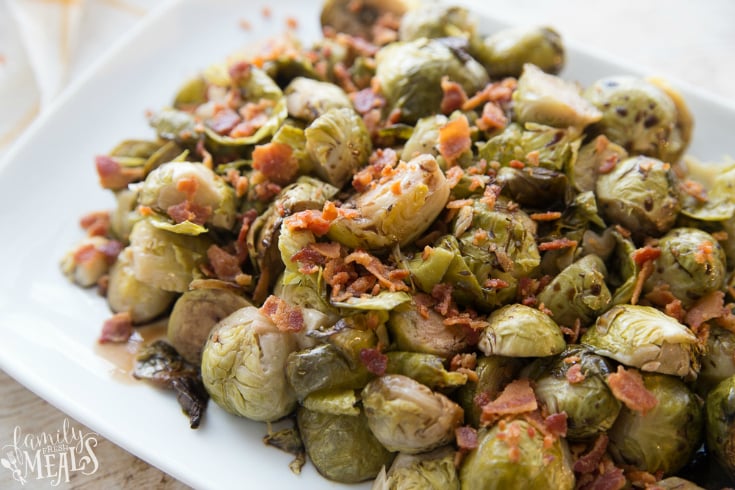 Crockpot Brussels Sprouts - Cooked Brussels Sprouts sprinkled with bacon, served on a white plate