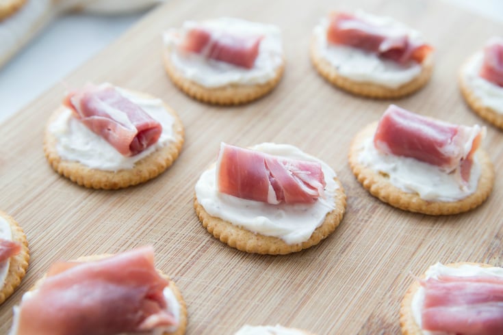 Easy Creamy Prosciutto Cracker Appetizer - Rolls of prosciutto on crackers