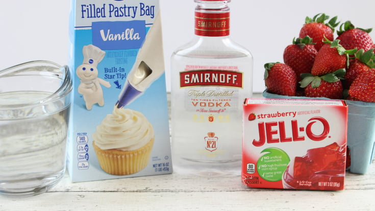 Santa Hat Holiday Jello Shots - ingredients laid out. Jello, strawberries, vodka and vanilla frosting