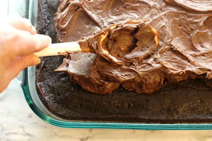 Sour Cream Chocolate Cake - spreading frosting on cake