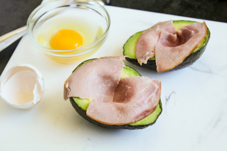 Avocado Egg Bake - Avocado sliced in half with ham sliced placed in avocado